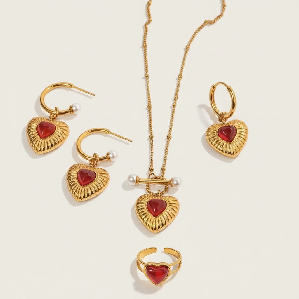 Seraphina Treasures gold-tone jewelry set with red agate heart pendants, pearl accents, and ribbed detailing. Includes necklace, hoop earrings, and ring.