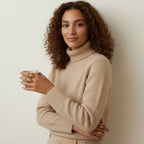 Seraphina Treasures Regara adjustable ring set with gold and silver finishes, worn by a model holding a glass of water.