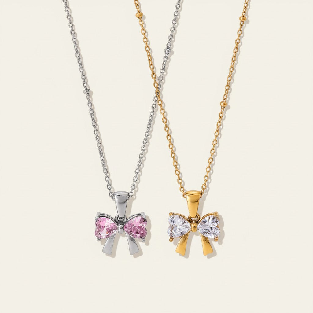 Seraphina Treasures Renenet necklace with bow pendant in silver with pink stones and gold with white stones.
