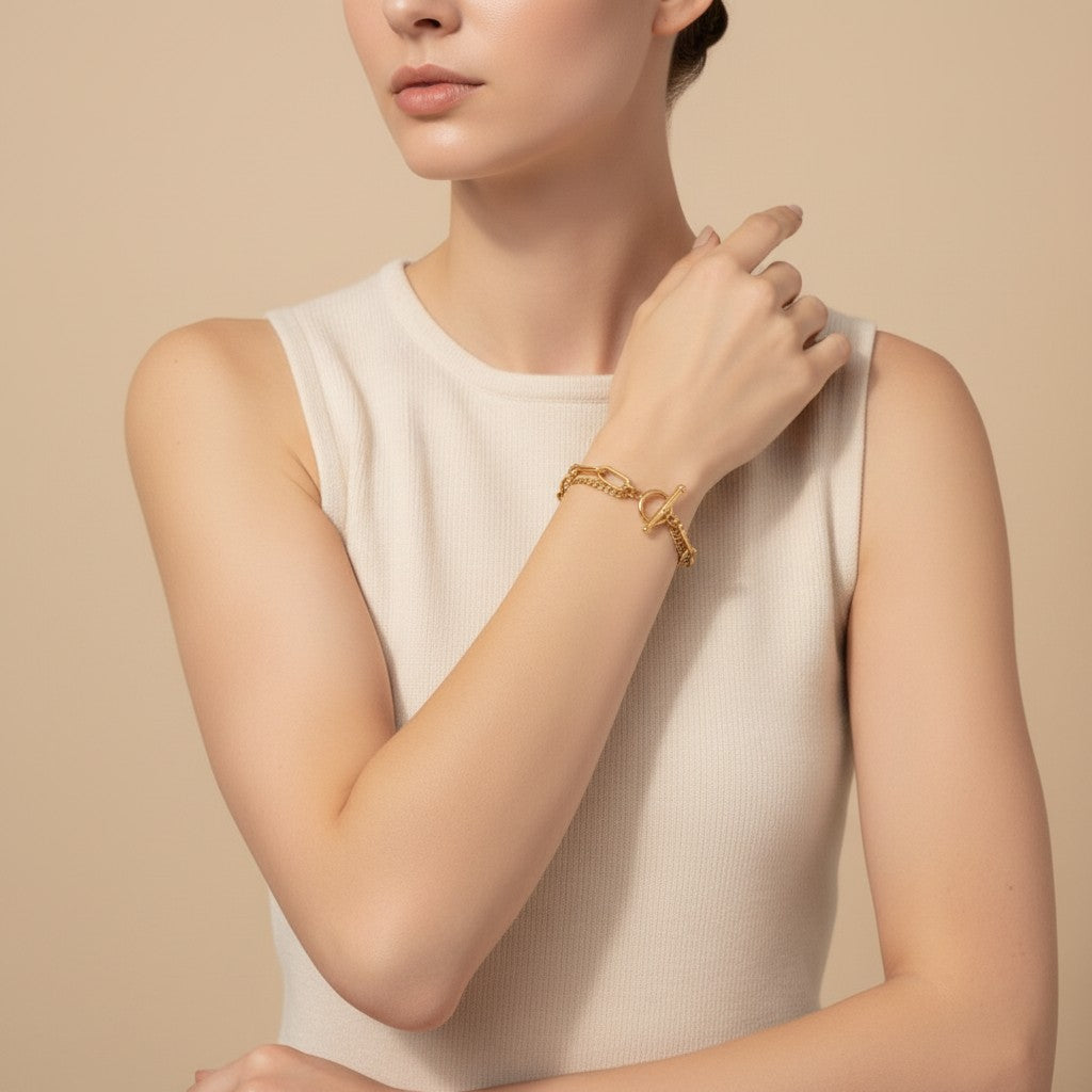Seraphina Treasures Rhea gold layered chain bracelet with toggle clasp on a woman's wrist.