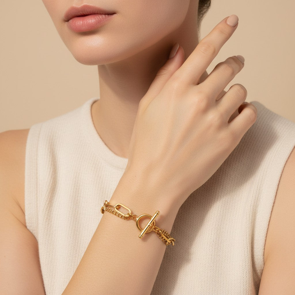 Seraphina Treasures Rhea gold layered chain bracelet with toggle clasp. Features interlocking oval and curb chains.