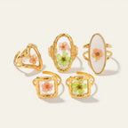 Seraphina Treasures Rosalune rings with real dried flowers in gold-tone settings. Features heart, oval, and square designs.