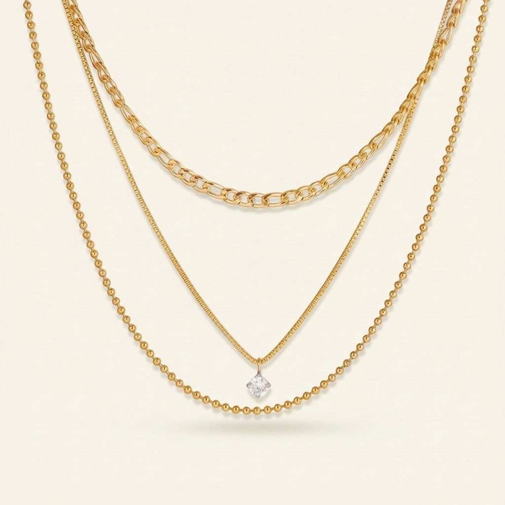 Seraphina Treasures Skotera gold layered necklace with zircon pendant. Features figaro, box, and bead chains.