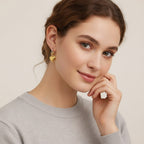 Seraphina Treasures Solarin gold heart dangle hoop earrings with chain detail.