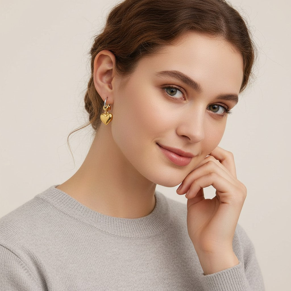 Seraphina Treasures Solarin gold heart dangle hoop earrings with chain detail.
