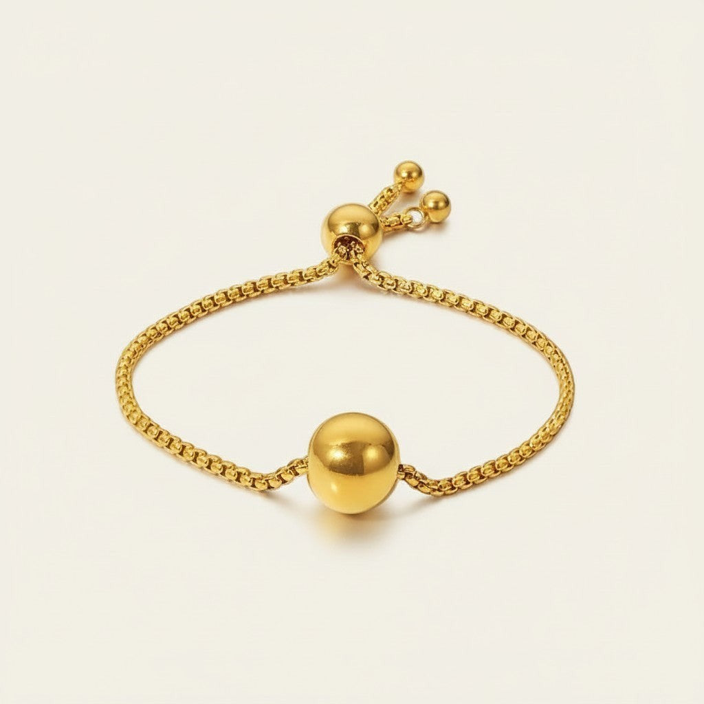 Seraphina Treasures Solis gold-tone adjustable bracelet with a smooth ball pendant and bead accents.
