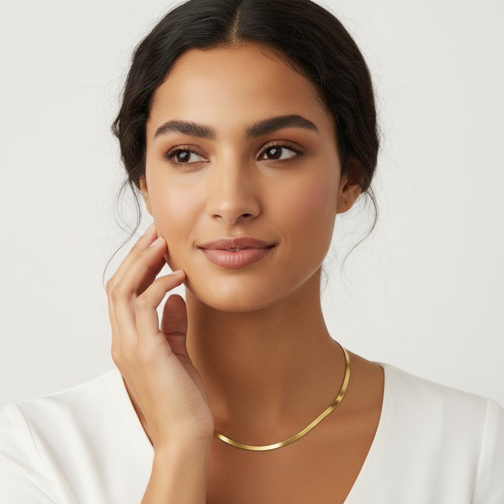 Seraphina Treasures Sterline gold herringbone necklace on a model. Smooth, flat chain adds subtle elegance.