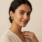 Seraphina Treasures Sylvara gold leaf earrings on a model. Lightweight and elegant.