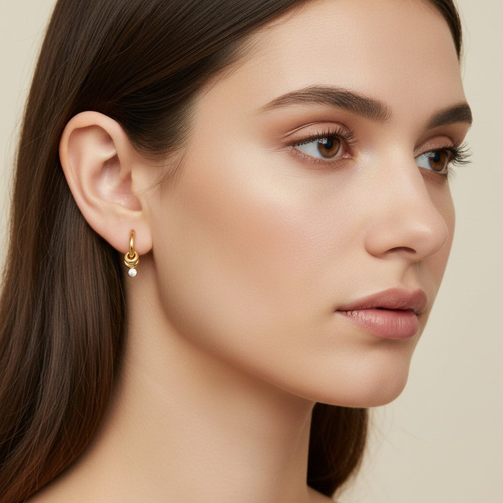 Seraphina Treasures Topazia gold hoop earrings with a knot detail and a dangling white zirconia stone.