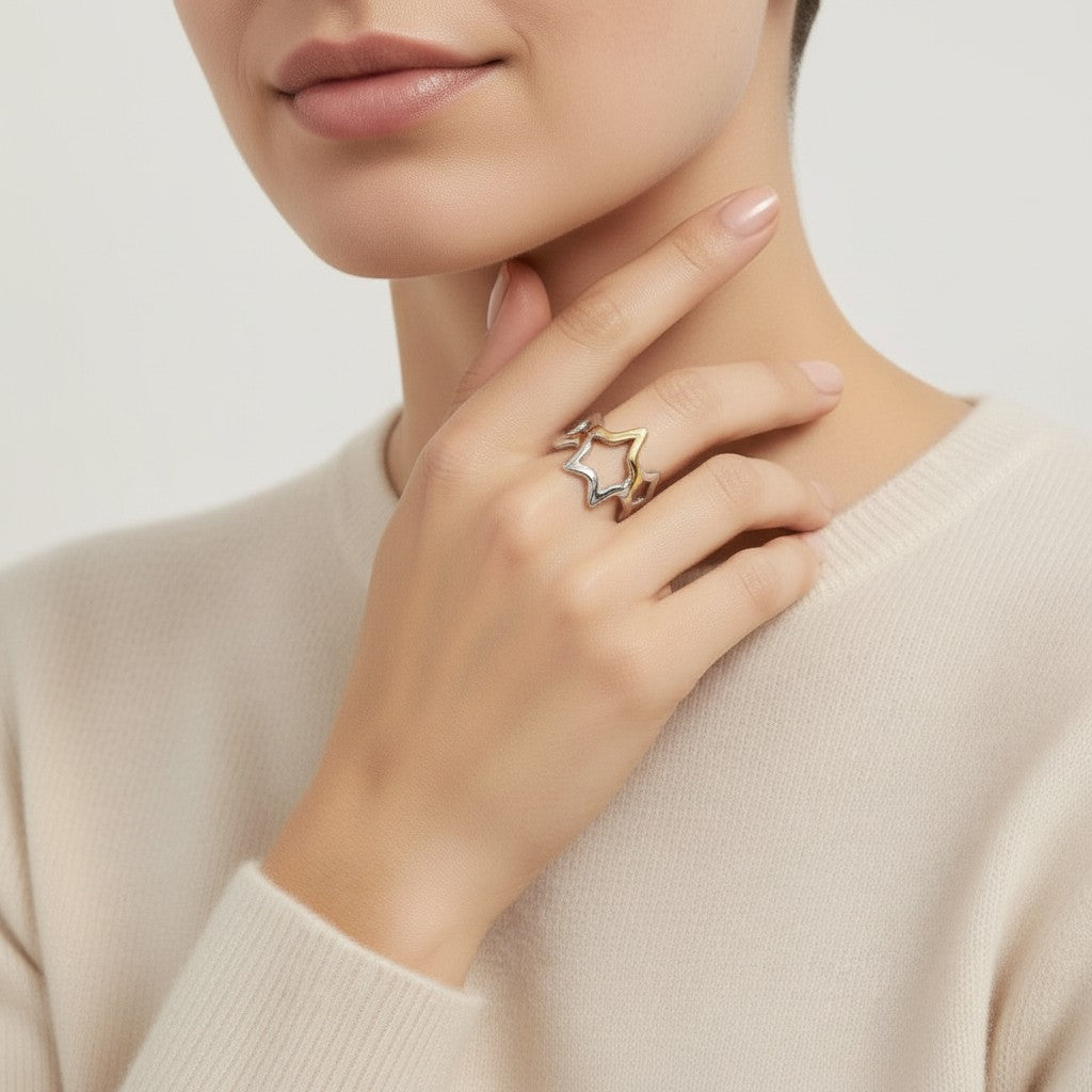 Seraphina Treasures Vespera ring with open star motifs in silver and gold tones on a model's hand.