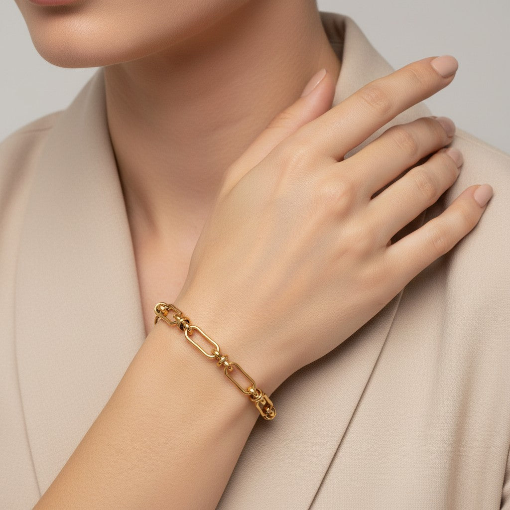 Seraphina Treasures Zephyra gold-tone stainless steel bracelet with open geometric links and knot details.